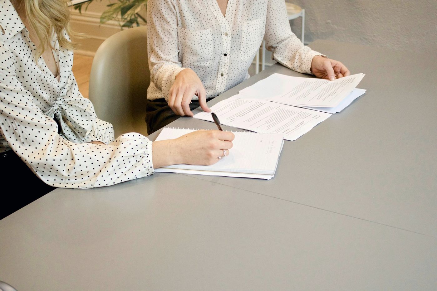 مهنيتان توقّعان مستندات على طاولة
